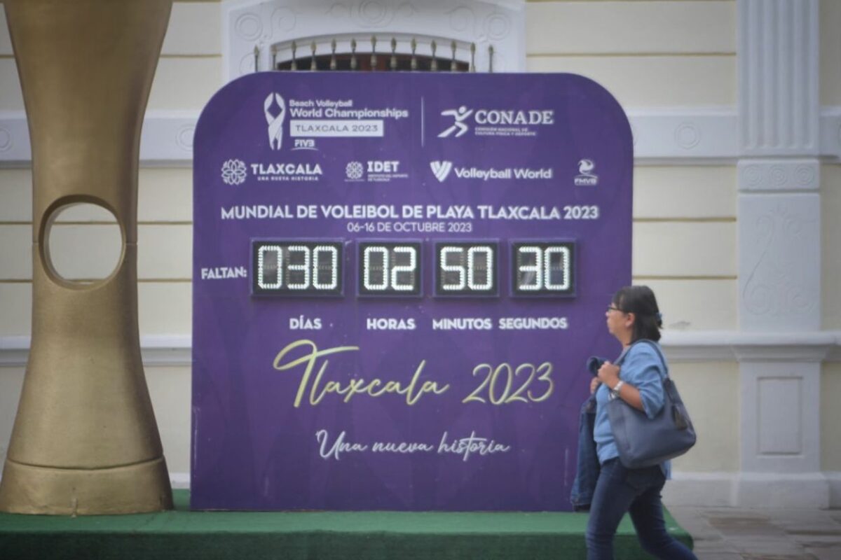 Transeúntes caminan frente al reloj de cuenta regresiva que marca exactamente un mes para el inicio del Mundial de Voleibol