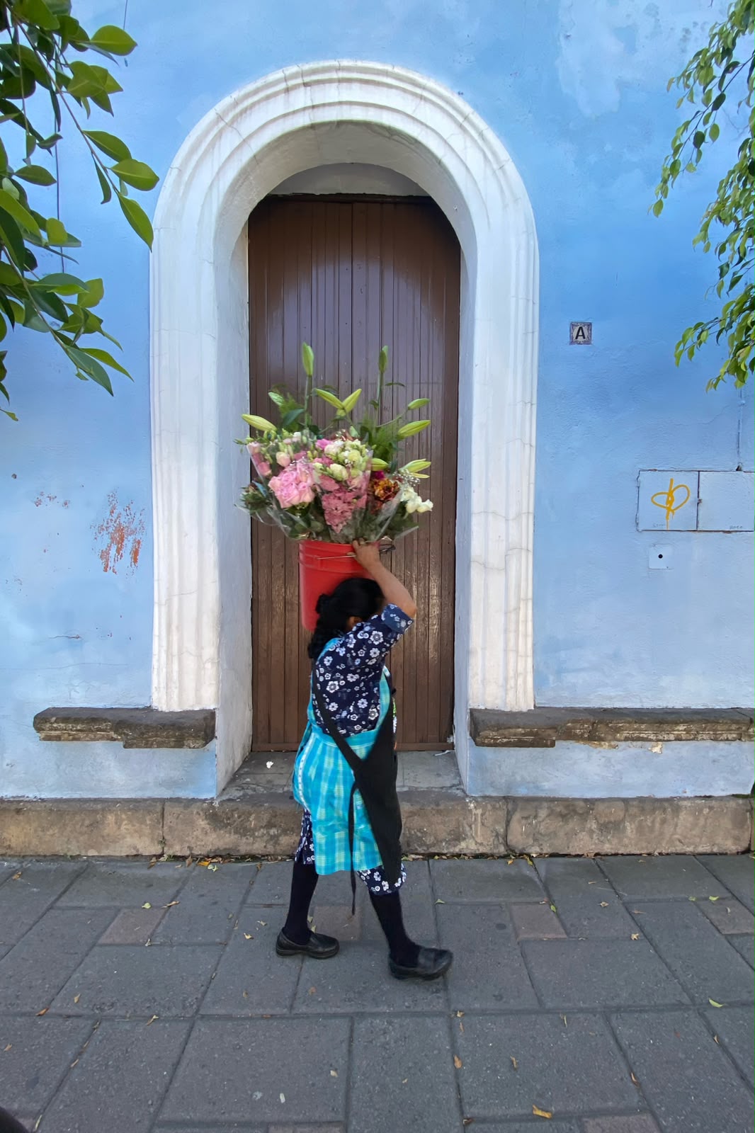 Una mujer vende flores de manera ambulante, esta mañana en calles del centro histórico de la capital de Tlaxcala